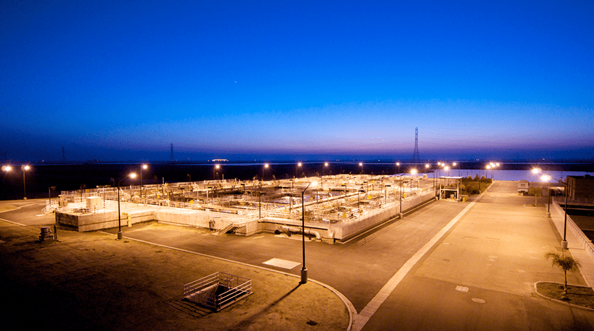 City of Fresno Fresno-Clovis Regional Wastewater Reclamation Facility at dusk with a dark blue sky.